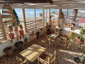 una habitación con mesas, sillas y algunas plantas en Miramar Surf Anza, en Agadir