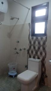 a bathroom with a white toilet and a window at Tripoo Rhisum the Haapo Retreat in Pelling