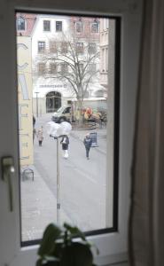 a window view of a street with people walking down the street at Ferienwohnung Blaßdörfer - Traumhafte Altbauwohnung mit Self-Checkin und 93 qm2 in Bad Kissingen