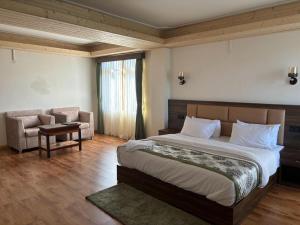 a bedroom with a large bed and a couch at Tripoo Rhisum the Haapo Retreat in Pelling