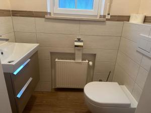 a bathroom with a white toilet and a sink at Wohnung mit top Küche in Untermeitingen