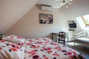 um quarto com uma cama com colcha floral em Gîte Les Hirondelles em Curgy