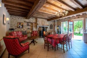 a dining room with a table and chairs and a fireplace at Gîte Les Hirondelles in Curgy