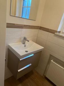 a bathroom with a sink and a mirror at Apartment with top kitchen and 3 sleeping rooms in Untermeitingen