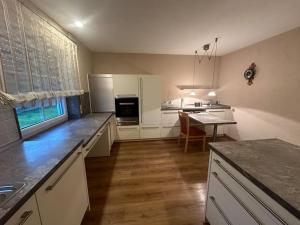 a kitchen with white cabinets and a table in it at Wohnung mit top Küche in Untermeitingen