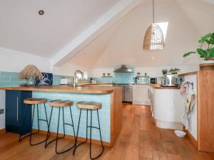 a kitchen with a blue island and stools at Sea View House in Newquay