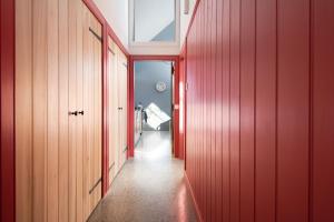 a hallway with red walls and a hallway with a door at Shepherd's Bothy at Papple Steading in East Linton