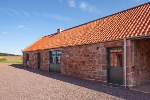 a brick building with two doors and an orange roof at Shepherd's Bothy at Papple Steading in East Linton