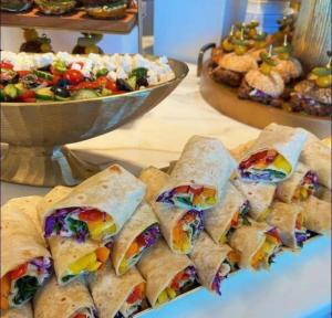 a bunch of sandwiches on a table with a salad at NN Jacaranda Guesthouse in Newcastle