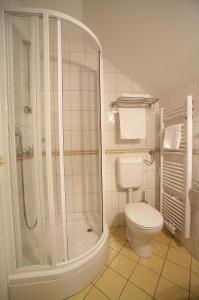 La salle de bains blanche est pourvue d'une douche et de toilettes. dans l'établissement Terme Zreče – Vile Terme Zreče, à Zreče