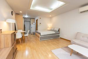 Jiny's Cozy Room في سول: غرفة نوم بسرير وطاولة واريكة