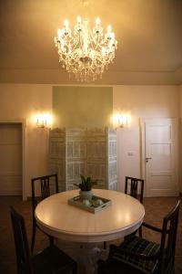 une salle à manger avec une table et un lustre dans l'établissement Belle Epoque, à Faenza