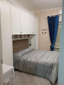una camera con letto e armadi bianchi di Appartamento 50 mt dal mare a Lido di Ostia