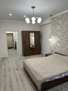 ein Schlafzimmer mit einem großen Bett in einem Zimmer in der Unterkunft Апартамент in Bischkek