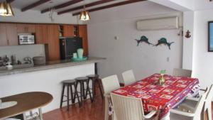 cocina y comedor con mesa y sillas en Casa en la playa, en Santa Elena