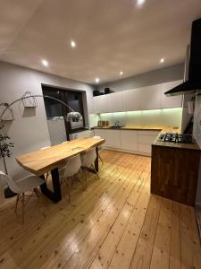 una cucina con tavolo in legno e pavimento in legno di Apartament BeskidSki 2 a Szczyrk