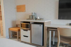a kitchen with a counter with a microwave and a table at The Boulevard Hotel in Beach Haven Gardens