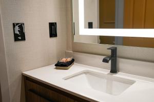 a bathroom with a sink and a mirror at The Boulevard Hotel in Beach Haven Gardens