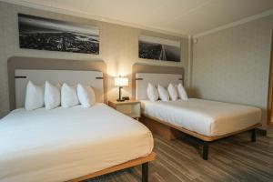 una camera d'albergo con due letti e due lampade di The Boulevard Hotel a Beach Haven Gardens