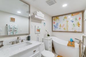 a bathroom with a tub and a toilet and a sink at Gulf Breeze Home with Deck Walk to Public Boat Ramp in Oriole Beach +18 photos