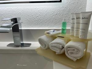Baño con estante con toallas y lavamanos en Radisson Hotel Schaumburg, en Schaumburg