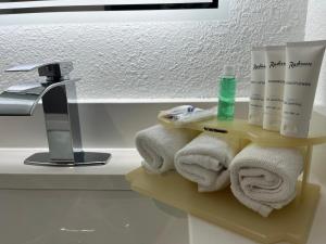 a bathroom with a shelf with towels and a sink at Radisson Hotel Schaumburg in Schaumburg