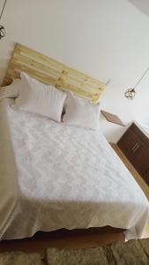 a bed with white sheets and pillows in a room at UE Home 203 in Duitama