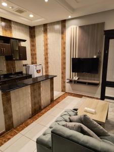 Verona فيرونا في الرياض: غرفة معيشة مع أريكة ومطبخ