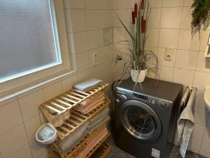 eine Waschmaschine im Bad neben einem Fenster in der Unterkunft Gästehaus Aarninkstraße in Nordhorn
