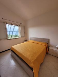 バリ・サルドにあるLa Casa Rosaのベッドルーム1室(黄色のベッドカバー付)