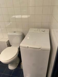 La salle de bains blanche est pourvue de toilettes et d'un lavabo. dans l'établissement Magnifique studio Parisien 12 ème arrondissement, à Paris