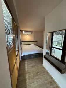 Къща за гости : غرفة نوم صغيرة بها سرير ونافذة