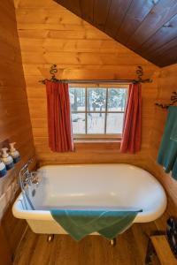 a bath tub in a cabin with a window at Storm Mountain Lodge & Cabins in Banff