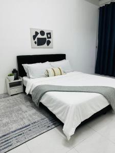 a bedroom with a large bed with white sheets at Adamhawa Homestay Emerald Avenue Brinchang in Brinchang