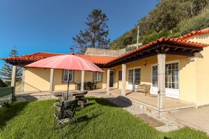 una casa con una sombrilla roja en el patio en Lovely Sunny-House, en Viana do Castelo