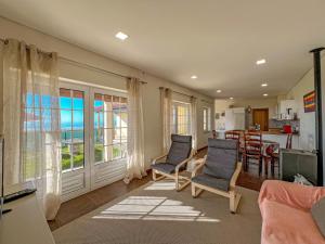 ein Wohnzimmer mit zwei Stühlen und einem Tisch in der Unterkunft Lovely Sunny-House in Viana do Castelo