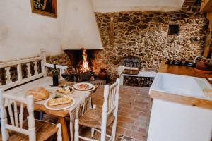 a kitchen with a table with bread and a fireplace at La Casita De Albino in Castillo de Bayuela