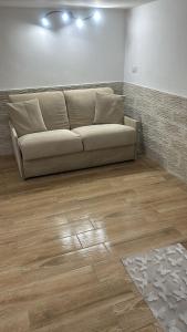 un sofá en una sala de estar con suelo de madera en A casa di ilary en Palermo