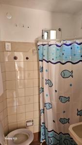 a bathroom with a toilet and a shower curtain at Apartamento Candombe in Montevideo