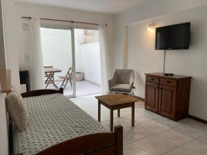 1 dormitorio con 1 cama, TV y mesa en Edificio San Martin 2468 en Mar del Plata