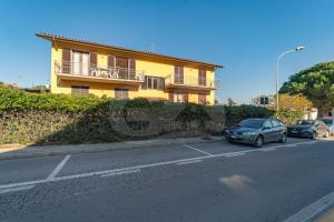 a car parked in a parking lot in front of a yellow house at Appartamenti La Marina - Goelba in Marciana Marina