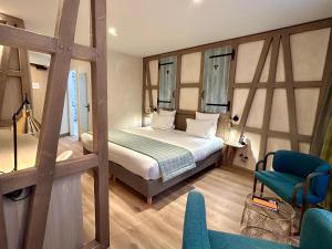sypialnia z łóżkiem i krzesłem w pokoju w obiekcie Hotel Beaucour w Strasburgu
