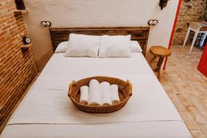 a basket of towels sitting on a bed at La Casita De Albino in Castillo de Bayuela