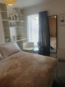a bedroom with a bed and a table and a window at Sweet Dreams in Luton