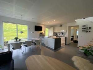 a kitchen and living room with a table and chairs at Luxury Cottage with Stunning Views - Okkara summarhús við Gjógv in Við Gjógv +31 photos