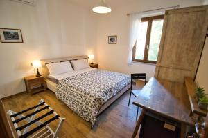 a bedroom with a bed and a desk and a window at Dommu Livia in Lotzorai +44 photos