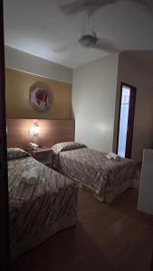 a hotel room with two beds and a window at Líber Hotel Nova Serrana in Nova Serrana