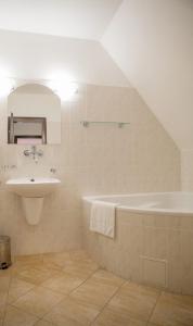 的住宿－Penzion Šiškův mlýn，浴室配有盥洗盆和浴缸。