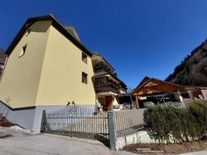 a yellow building with a fence in front of it at Tiha dolina in Železniki