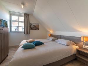 1 dormitorio con 1 cama grande y 2 almohadas en Vintage Holiday Home in Colijnsplaat near Forest, en Colijnsplaat